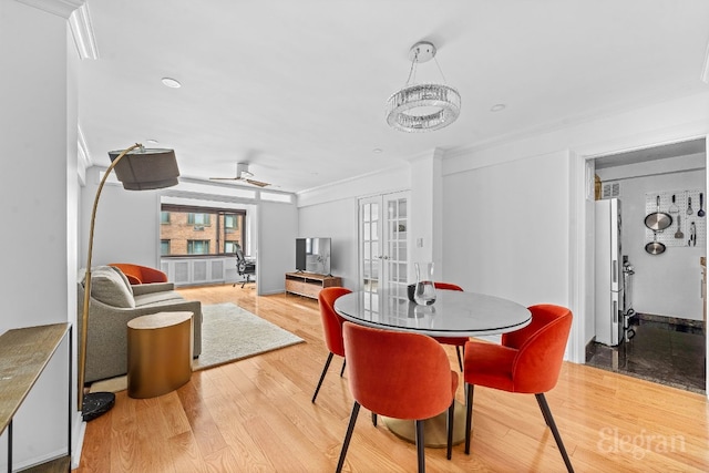 dining space with crown molding, french doors, ceiling fan, and light wood-type flooring