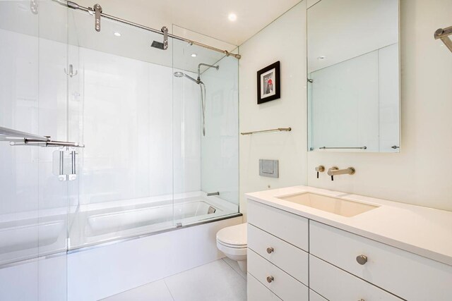 full bathroom featuring toilet, combined bath / shower with glass door, tile patterned floors, and vanity