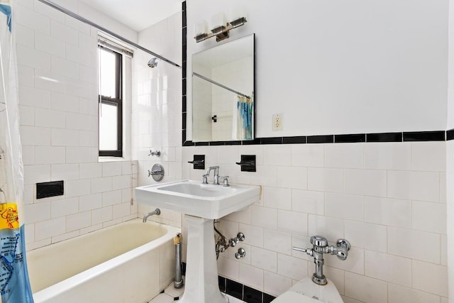 bathroom with shower / bath combination with curtain, sink, and tile walls