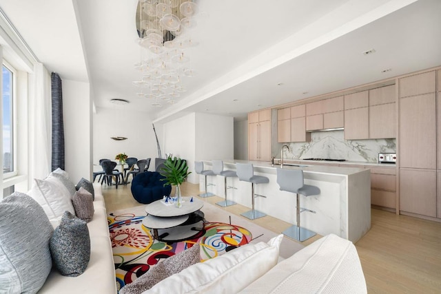 living room featuring sink and light hardwood / wood-style floors