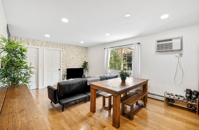 dining area with light hardwood / wood-style flooring and a wall unit AC