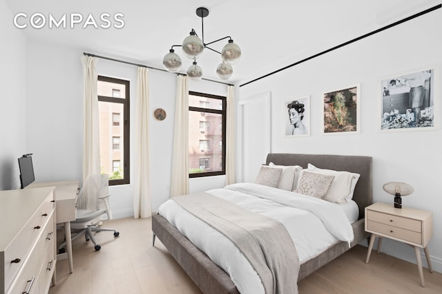 bedroom featuring a chandelier and light wood-style flooring