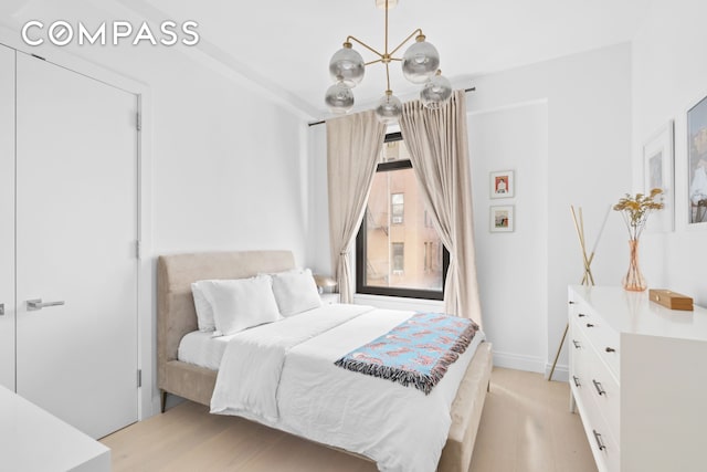 bedroom with baseboards and a notable chandelier