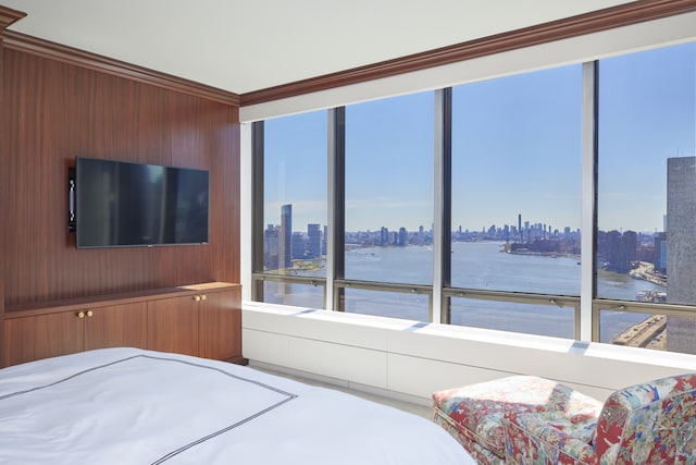 bedroom with crown molding, wood walls, and a city view