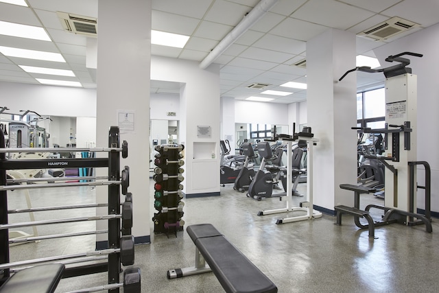 exercise room with a paneled ceiling and visible vents