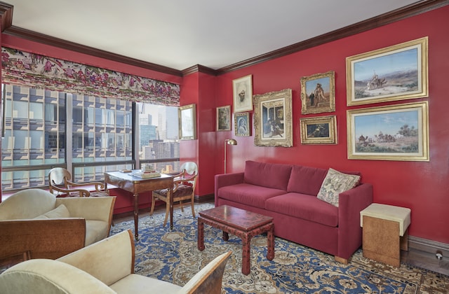 living area featuring crown molding, baseboards, and wood finished floors