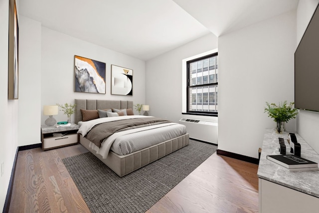 bedroom with radiator heating unit and hardwood / wood-style floors