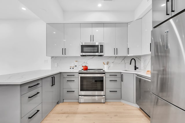 kitchen with modern cabinets, stainless steel appliances, and gray cabinetry