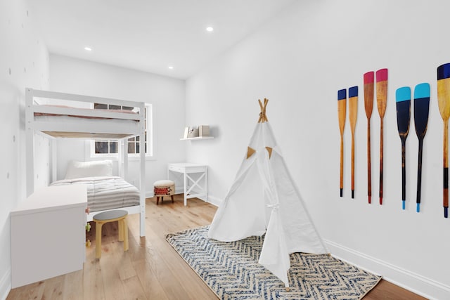 playroom featuring baseboards, wood finished floors, and recessed lighting