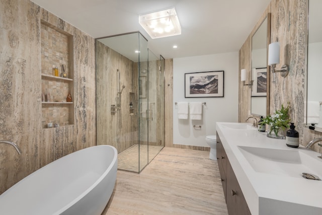 bathroom with double vanity, a soaking tub, a sink, and a stall shower