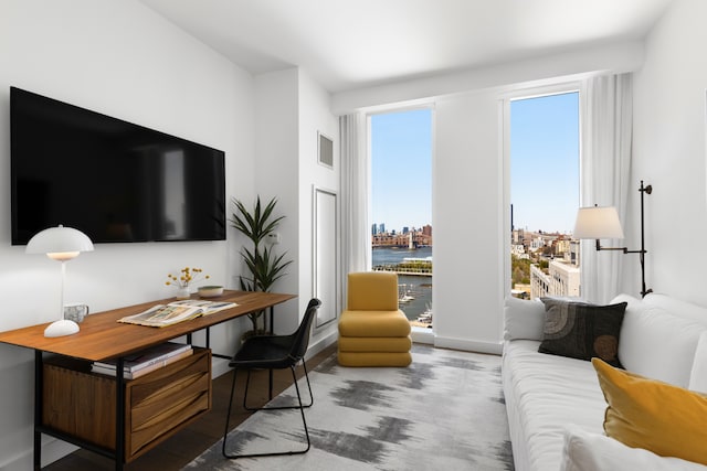 living area featuring a city view, visible vents, and baseboards