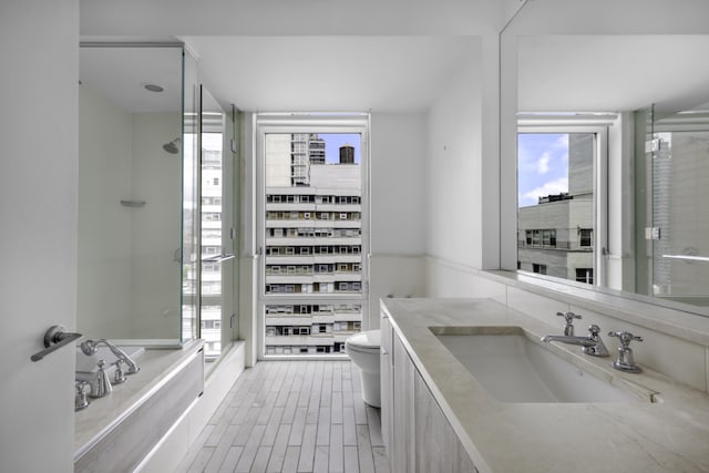 full bathroom featuring toilet, vanity, and separate shower and tub