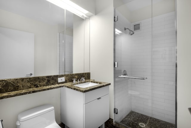 bathroom with walk in shower, vanity, and toilet