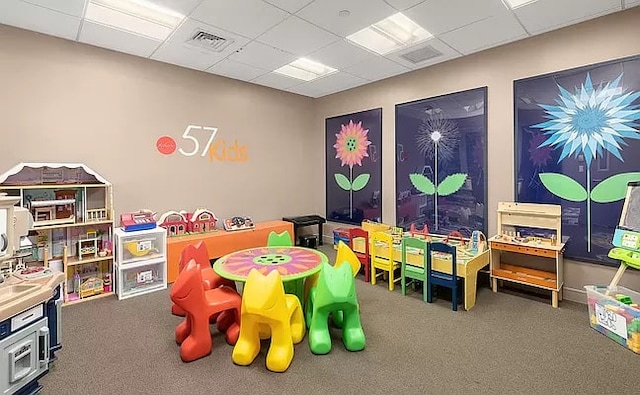 playroom featuring carpet floors and a paneled ceiling