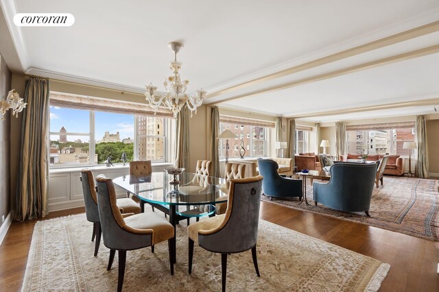 dining space featuring a notable chandelier, crown molding, wood-type flooring, and a healthy amount of sunlight