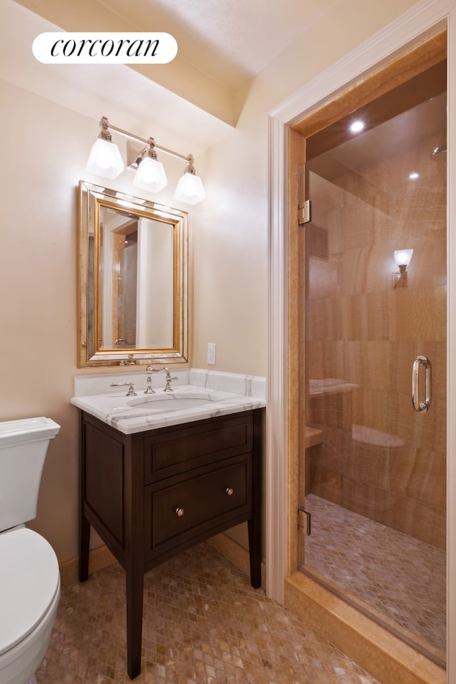 bathroom with a stall shower, vanity, and toilet