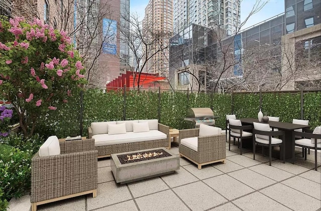 view of patio / terrace with area for grilling and an outdoor living space with a fire pit