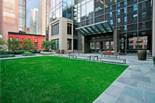 view of property's community with a city view and a lawn