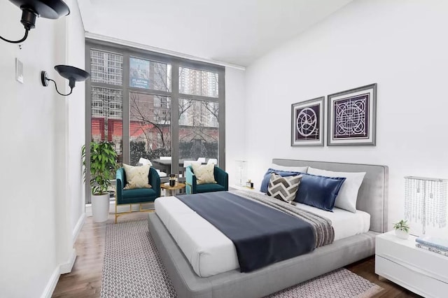 bedroom with a wall of windows and dark wood-type flooring