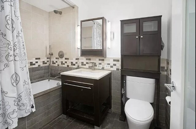 full bathroom featuring vanity, tile patterned flooring, tile walls, toilet, and tiled shower / bath