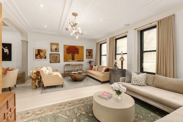 living room with crown molding, a healthy amount of sunlight, and a chandelier