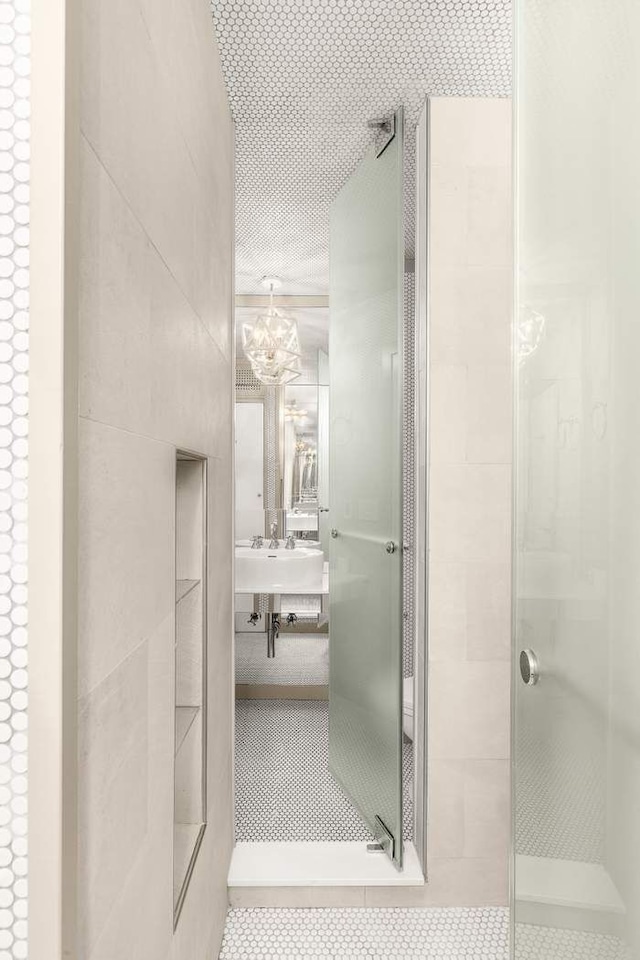 full bathroom with a stall shower, tile patterned floors, a notable chandelier, and vanity