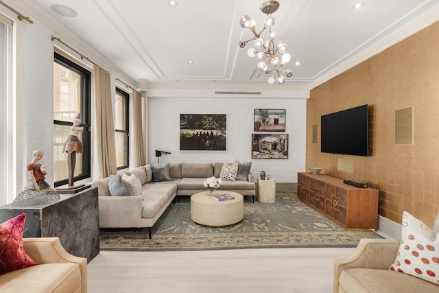 living room with a notable chandelier, crown molding, and wood finished floors