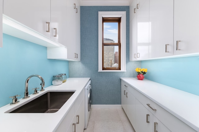 clothes washing area with light tile patterned floors, a sink, cabinet space, and washer and clothes dryer