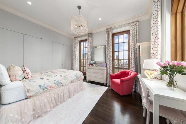 bedroom featuring two closets, crown molding, and wood finished floors