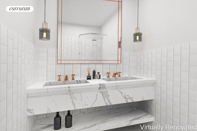 bathroom featuring a bathing tub, sink, and tile walls