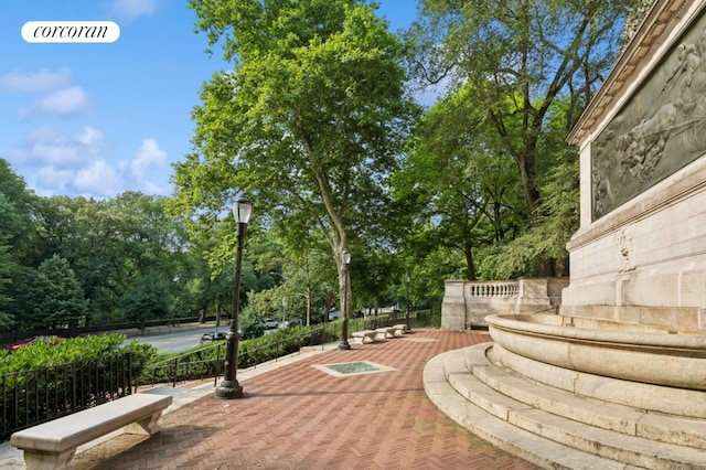 view of community featuring a patio and tennis court