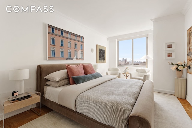 bedroom featuring baseboards, ornamental molding, and wood finished floors