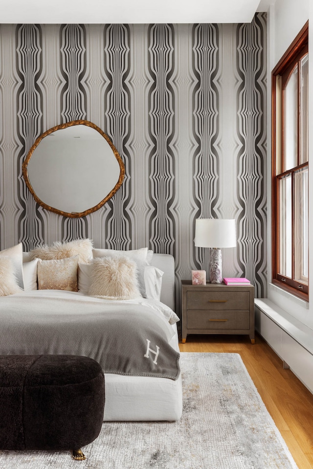 bedroom with multiple windows and wood finished floors