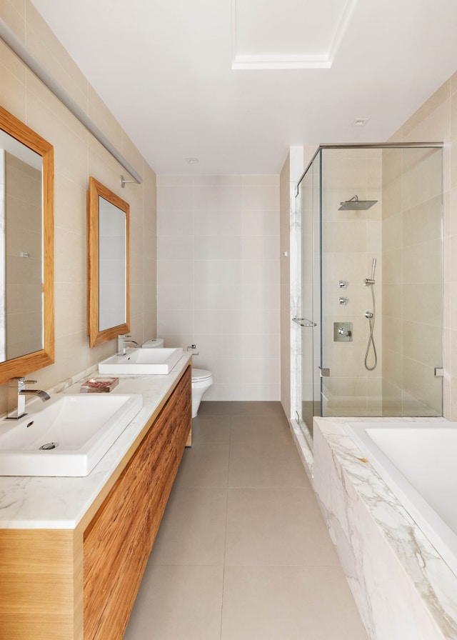 full bath with a shower stall, tile walls, tile patterned floors, a bath, and double vanity