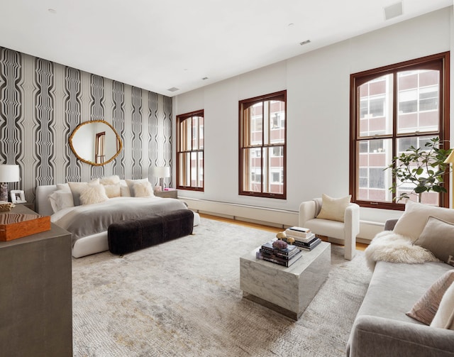 bedroom with visible vents, multiple windows, wallpapered walls, and an accent wall