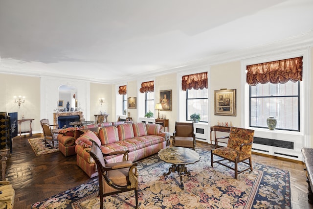 living room with a healthy amount of sunlight, crown molding, and dark parquet floors