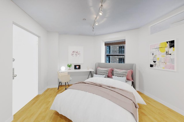 bedroom featuring light hardwood / wood-style floors and rail lighting