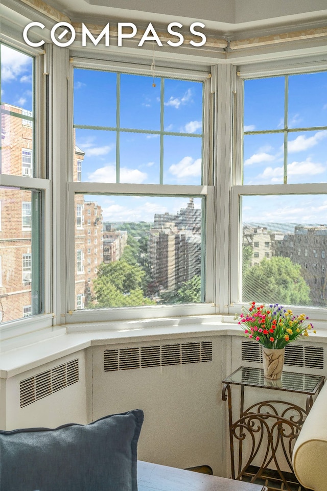 interior space featuring a healthy amount of sunlight, a city view, and radiator heating unit