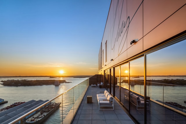 view of dock featuring a water view and a balcony