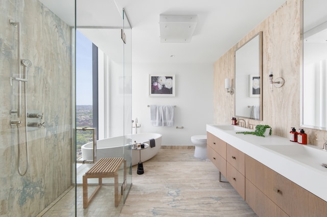 bathroom with a walk in shower, a soaking tub, double vanity, and toilet
