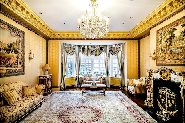 living area with a notable chandelier, wood finished floors, crown molding, wallpapered walls, and baseboards