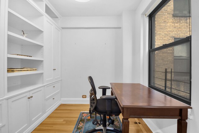 office area featuring built in shelves and light hardwood / wood-style floors