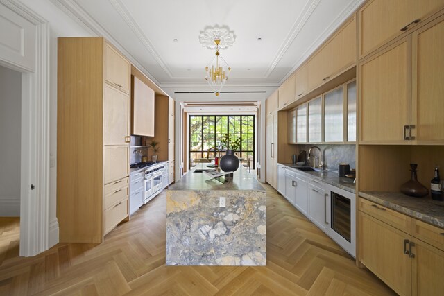 kitchen with sink, beverage cooler, light parquet floors, double oven range, and a center island