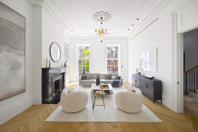living area with stairs, a chandelier, a fireplace with flush hearth, crown molding, and a tray ceiling