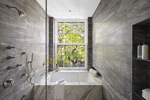 bathroom featuring a garden tub and a tile shower