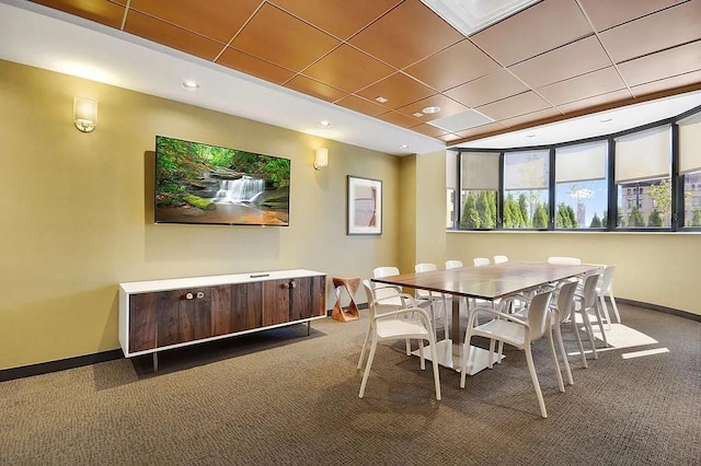 dining area featuring a drop ceiling, carpet, and baseboards