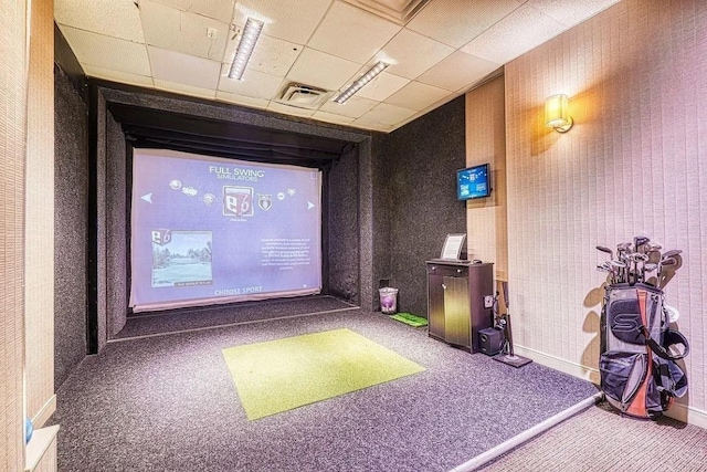 recreation room with golf simulator, carpet flooring, and a paneled ceiling