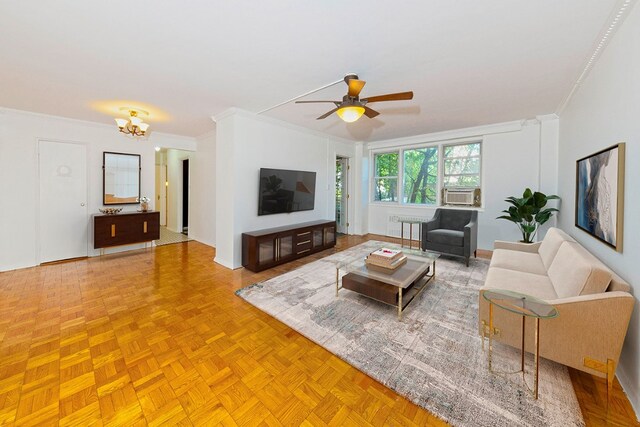 living room featuring light parquet flooring, ornamental molding, and ceiling fan with notable chandelier