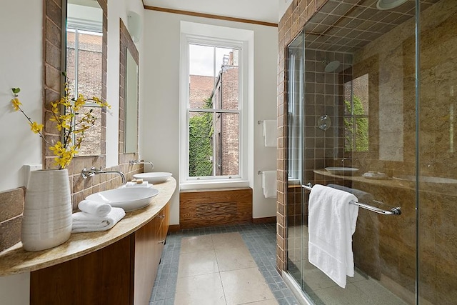 full bathroom with a sink, a healthy amount of sunlight, a stall shower, and tile patterned flooring