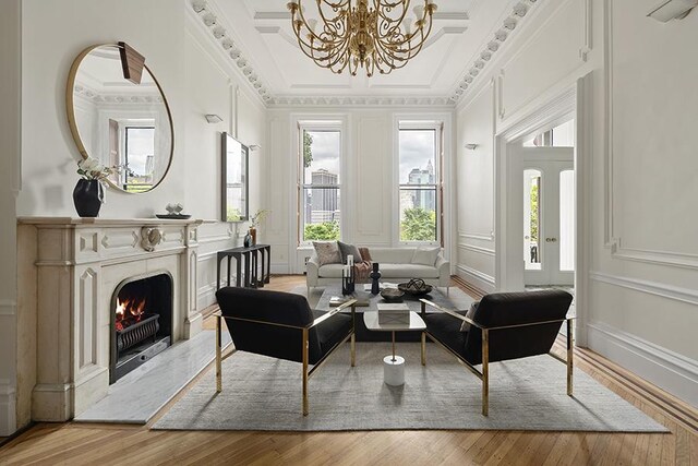 living area with hardwood / wood-style flooring, crown molding, and a chandelier